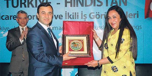TUSKON head Rızanur Meral (L) extends a plate to India’s FICCI Vice President Jyotsna Suri (R). (Photo: Reuters)