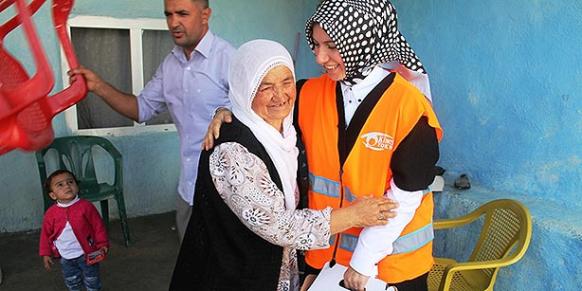 A woman in the village of Bilge in Mardin province greets a Kimse Yok Mu volunteer (R) during an aid mission on Oct. 5. (Photo: Cihan)