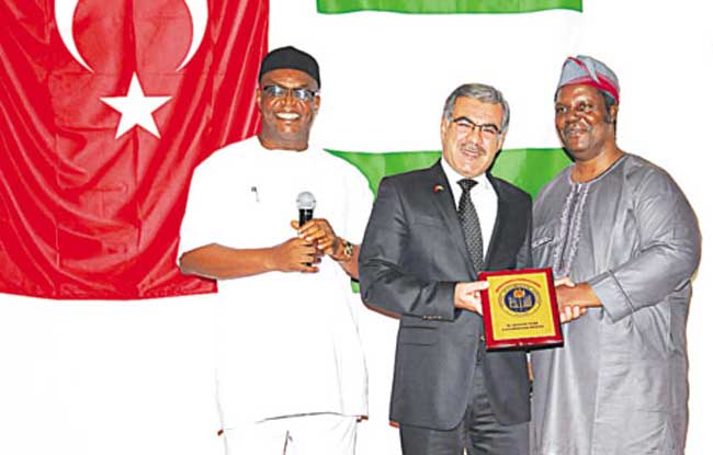 Chief Executive Officer, National Mathematical Centre (NMC), Prof Adewale Solarin (right), Group Managing Director, Nigeria Turkish International Colleges (NTIC), Mehmet Basturk and Chairman of Governing Council of West African Examinations Council, Daniel Uwazurike, during the presentation of NMC 2014 Awards to Basturk at the Sheraton Hotels, Abuja