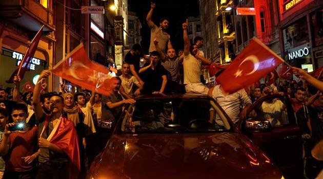 People chant slogans during a pro-government rally in central Istanbul's Taksim square, Saturday, July 16, 2016. Forces loyal to Turkish President Recep Tayyip Erdogan quashed a coup attempt in a night of explosions, air battles and gunfire that left some hundreds of people dead and scores of others wounded Saturday. (AP Photo/Bram Janssen)