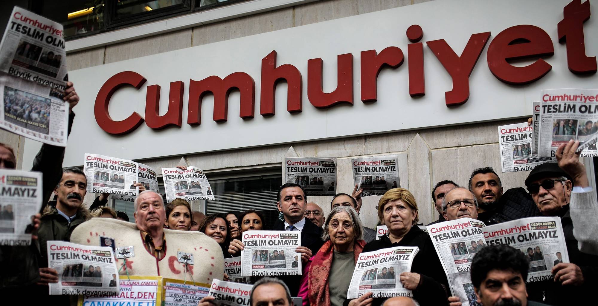 Protesters hold copies of the latest edition of the Turkish daily newspaper 
